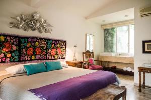 a bedroom with a large bed with a colorful headboard at Casa de las Bugambilias B&B in Oaxaca City