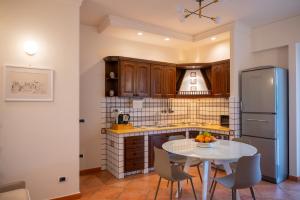 a kitchen with a table and a refrigerator at DONNA FRANCA in Taormina
