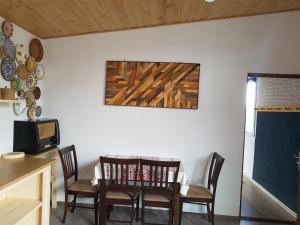 a dining room with a table and chairs and a painting at Casa CeDar in Lupeni