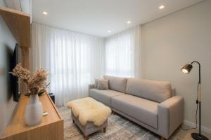 uma sala de estar com um sofá e uma mesa em Villa di Tondo House II-Lindo apartamento em Bento Gonçalves