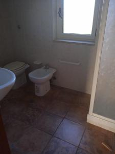 a bathroom with a sink and a toilet and a window at I giardini del castello in Mandatoriccio Marina