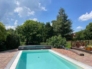 a swimming pool in a yard with trees at Spacious 3 bedroom house with heated pool in Szigliget