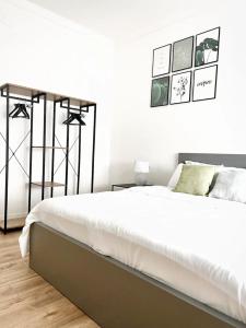 a white bedroom with a large bed and a white wall at Beno House Brescia in Brescia