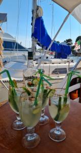 a group of three martini glasses on a table with a boat at LUPA - La flotta di Willy Giò in Alghero