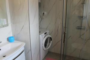 a bathroom with a washing machine and a shower at Apartment Mihael in Cavtat