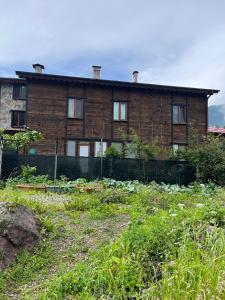 a brick house with a garden in front of it at ESPİRA APART in Çaykara