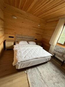 ein Schlafzimmer mit einem Bett in einem Holzzimmer in der Unterkunft ESPİRA APART in Çaykara