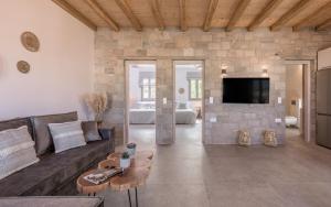 a living room with a couch and a stone wall at Esperanza Apartments in Adamantas