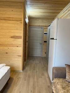 a living room with a refrigerator and wooden walls at ESPİRA APART in Çaykara