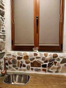 un lavabo con una pared de piedra junto a una puerta en Πέτροκτιστο Σπίτι. Stone House en Ayía Kiriakí