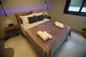 a bedroom with a large bed with two towels on it at Animus Premium apt in Nafplio