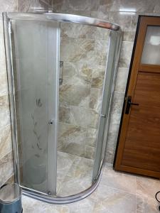 a shower with a glass door in a bathroom at ESPİRA APART in Çaykara