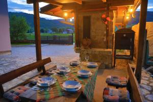 a table with plates and wine glasses on a patio at Apartman Enjoy in Bihać