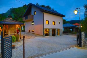 a large white house with a street light next to it at Apartman Enjoy in Bihać