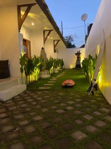 a house with a surfboard laying on the grass at Five Rooms in Canggu +6 photos