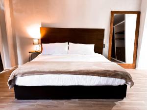 a bedroom with a large bed with a wooden headboard at Hotel Santa María in Taxco de Alarcón