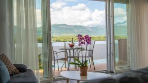 a living room with a table and a balcony at Apartments Edera in Tivat