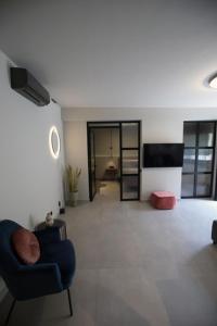 a living room with a blue chair and a television at Animus Premium apt in Nafplio