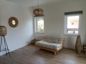 a living room with a couch and two windows at Vivenda Geminada com piscina a 10 minutos a pé da praia in Portimão