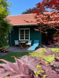 two chairs and a table in front of a house at Ferienwohnung Zur Heide in Rheine