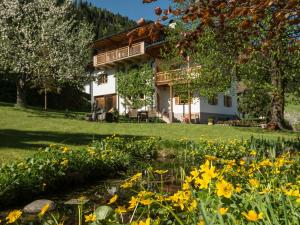 ein Haus mit einem Teich und Blumen im Hof in der Unterkunft Haus Francazi Sillian in Sillian