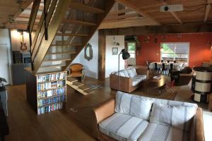 a living room with a couch and a staircase at La Maison de l'Aérogrange in Biscarrosse