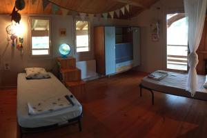 a living room with two beds and a television at La Maison de l'Aérogrange in Biscarrosse