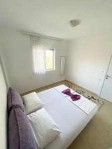 - un lit blanc dans une chambre avec fenêtre dans l'établissement Lulu Garden, à Ulcinj