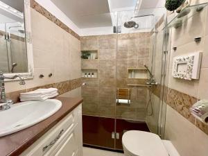 uma casa de banho com um chuveiro, um lavatório e um WC. em Lux apartament em Focşani