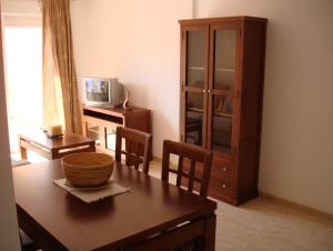 ein Wohnzimmer mit einem Holztisch und einem Schrank in der Unterkunft SALINAS DE VERA APARTAMENTO in Vera