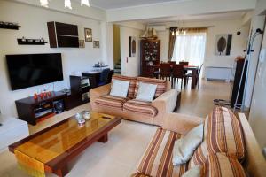 ein Wohnzimmer mit einem Sofa und einem Tisch in der Unterkunft Fou's luxury apartment in Nafpaktos