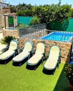 un grupo de sillas sentadas junto a una piscina en Casa Rural Los Mayorales, en Esparragalejo