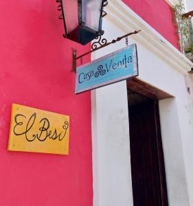 a sign on the side of a pink building at El Beso Rooms in Cartagena de Indias