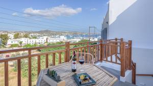 a table with a bottle of wine on a balcony at Esperanza Apartments in Adamantas