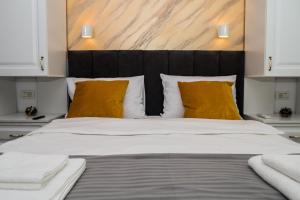 una camera da letto con un grande letto con cuscini gialli di Apartament Zeuss Neptun a Neptun