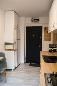 una cucina con armadietti bianchi e una porta nera di Apartament Zeuss Neptun a Neptun