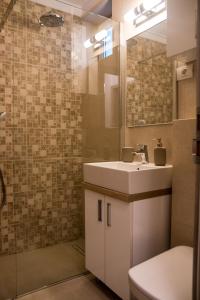 La salle de bains est pourvue d'un lavabo et d'un miroir. dans l'établissement Apartament Zeuss Neptun, à Legian
