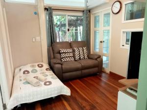 a living room with a couch and a chair at Casa Bonita Kanchanaburi in Kanchanaburi