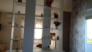 een witte boekenplank in een kamer met een raam bij Bed&breakfast Albysuite in Termoli