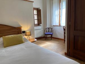 a bedroom with a bed and a blue chair at Mulino del Casale - nature b&b in San Paolo Solbrito