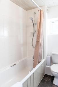 uma casa de banho branca com uma banheira e um WC em Bomaquarters COSY AND LUXURIOUS 2 BED VILLIERS HOUSE em Coventry