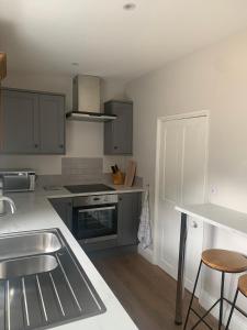 a kitchen with a sink and a stove top oven at Tipsy Cottage Charming 2 bedroom home. in Burley in Wharfedale