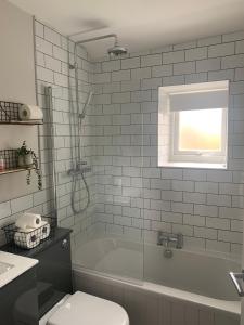 a bathroom with a tub and a toilet and a sink at Tipsy Cottage Charming 2 bedroom home. in Burley in Wharfedale