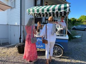 a woman standing in front of a hot dog cart at Pensionat Grisslehamn in Grisslehamn