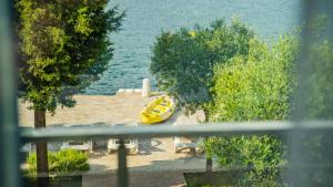 a yellow kayak sitting on a beach next to the water at Apartments Edera in Tivat