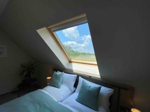 ein Schlafzimmer mit einem Fenster über einem Bett mit Kissen in der Unterkunft Pool Sauna Entspannung in Rangsdorf