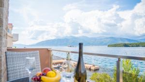 a table with a glass of wine and a view of the water at Apartments Edera in Tivat