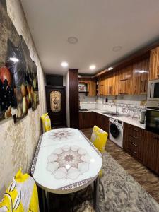 a kitchen with a white table and yellow chairs at Darhan in Tashkent
