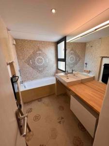 een badkamer met een bad, een wastafel en een spiegel bij Maison de village le Barroux *Clim* in Le Barroux