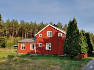une maison rouge au milieu d'un champ dans l'établissement Gamla Kooperativa, à Ekshärad